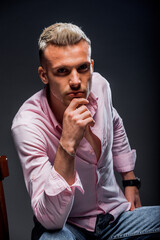 Handsome flirting attractive caucasian male in light pink shirt