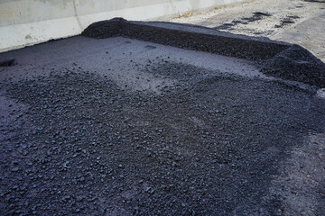 The highway construction site is paving the new asphalt pavement.