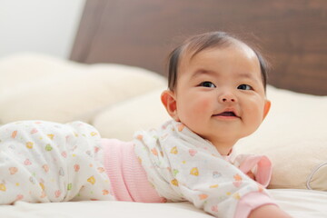 寝室のベッドで寝転がる赤ちゃん