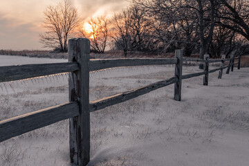 fence in winter at sunset