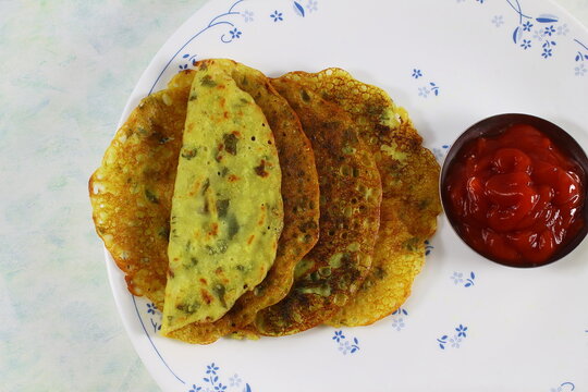 indian gujarati traditional home made tea time snack methi pudla or methi puda with sauce