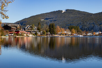 Fototapeta premium Titisee-Neustadt, Germany - 10 30 2012: surroundings of Titisee, european village in beautiful winter cold day. Scenery is reflected in the lake. 
