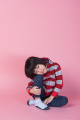 Portrait beautiful kid in the studio on pink background
