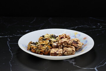 Pile of Classic baked mixed nut and grain serving on the plate. Famous traditional welcome sweet snack in Asia party. 