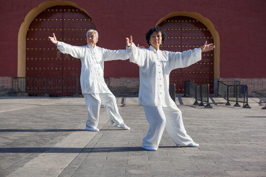 Two old people playing Tai Chi in the park