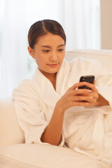 A young woman wearing a bathrobe call 