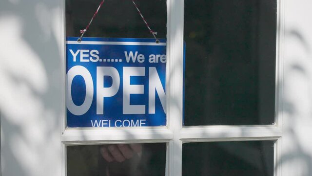 Business open sign being flipped to closed sign at the end of the business day, in slow motion