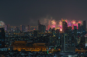 Obraz premium Colorful Firework with cityscape night light view of Bangkok skyline at twilight time. New Year celebration fireworks, Bangkok city,Thailand Fireworks light up to sky at Christmas & New Year festival 