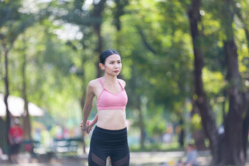 Fototapeta premium Asian woman warm up and doing yoga with stretching legs outdoor in the park. Woman wearing sportswear and working out outdoor. Yoga and exercise outdoor concept