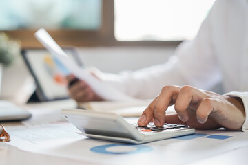 close up hands of accountant calculating tax refund using calculator