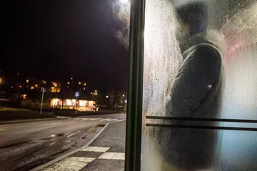 Foto auf Acrylglas Stockholm Stockholm, Sweden A man waits for a bus in the Lidingo suburb in the rain.