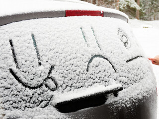 Drawing in the snow. Emoticons on the car in winter.