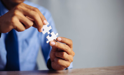 Closeup hand of man connecting jigsaw puzzle with sunlight effect, Business solutions, success and...