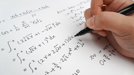 Fototapeta premium Handwriting to solve math formulas holding a computer pen. Math Formulas solves the test, practice, test or exam, background concept in math class.