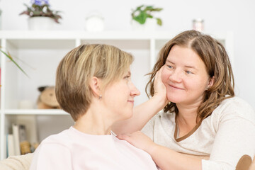 Caucasian gay couple talking, having conversation on sofa at home. Two women in love with each other, discuss problems in their relationships and solve problems
