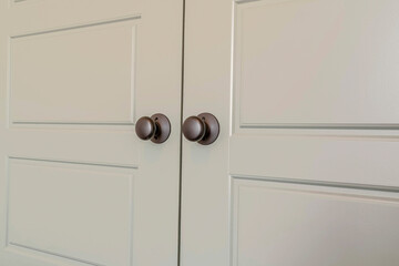 Wooden panelled double doors with shiny round doorknobs at the bedroom entrance