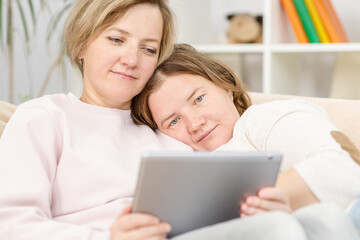 Happy lesbian couple embracing and using tablet computer at home.  Lesbian couple concept