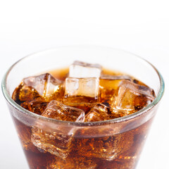 Close-up Cola in glass with ice on white background.