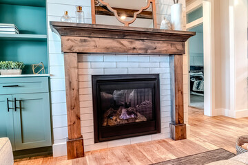 Modern fireplace with wooden frame against white wall inside living area of home