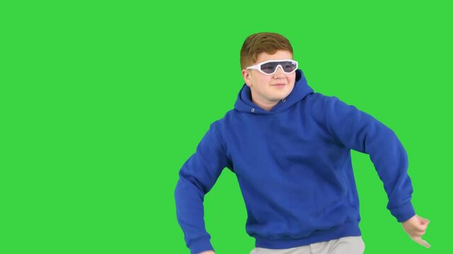 Happy boy in shades dancing really cool on a Green Screen, Chroma Key.