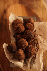Top view of chocolate truffles on a wooden plank in dark aesthetic. Keto dessert