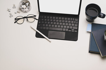 Above shot workspace with tablet on keyboard, coffee, books. Table of creative concept.