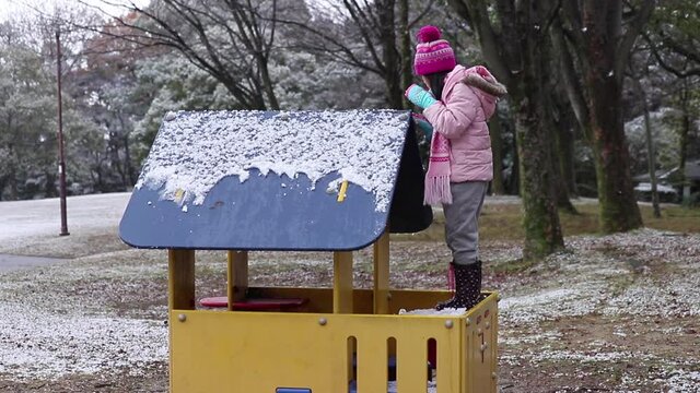 冬の公園の小屋で雪遊びしている可愛い子供