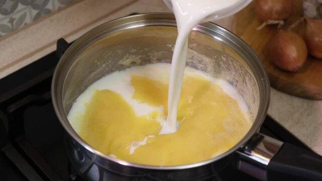 Preparation of bechamel sauce in a pan. Home kitchen.