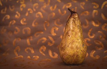 ripe abbot pear isolated on ecru background and golden symbols.