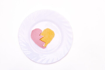 On a white plate, sausage and cheese in the shape of a heart. The concept of Valentine's day.