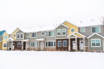 Apartment houses in a snowy neighborhood with cloudy sky background in winter
