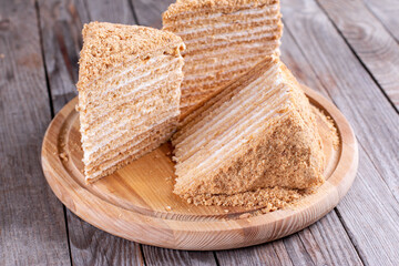 Layer honey cake Medovik on a wooden table. Traditional layer cake with honey cream