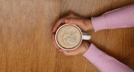 Cup of coffee in female hands. Nice coffee break. Hot morning drink.