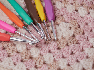 Needlework crochet, top view of yarn balls, flat spoon on light wood close-up