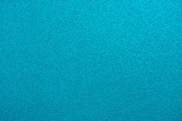 Abstract background in turquoise color. An empty, flat surface with a fine texture. Blank for a message or the backdrop of a billboard