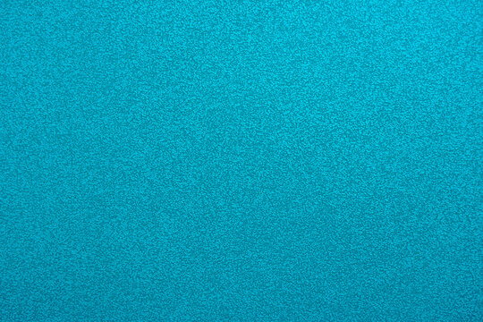 Abstract background in turquoise color. An empty, flat surface with a fine texture. Blank for a message or the backdrop of a billboard