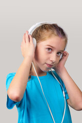 A brown eyed girl wearing headphones and listening to music