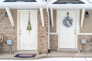 Entrance to apartments with festive wreaths on the white wooden front doors