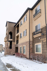Multi storey apartment in a snowy neighborhood against white sky in winter