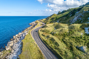 Causeway Costal Route mit Autos, auch bekannt als Antrim Coastal Road an der Ostküste von Nordirland, Vereinigtes Königreich.