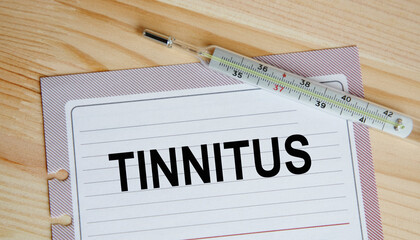 On a sheet from the diary of tinz TINNITUS, next to the thermometer.