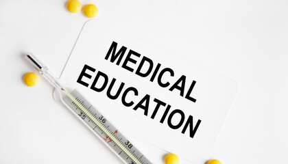 On the card text MEDICAL EDUCATION, next to the thermometer and yellow tablets.