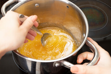 Honey in a saucepan on the stove for gingerbread dough
