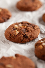 Chocolate cookies on white torn paper.