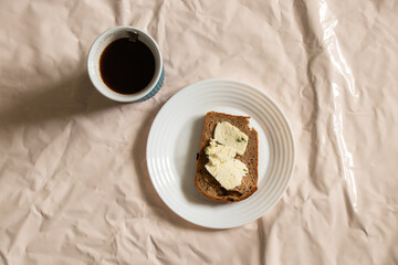 blue cup with coffee and sandwich with bread and feta cheese on a plate on the table
