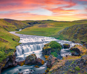 Fantastic waterfall on Skoga river. Colorful summer sunrise in outskirts of Skogafoss waterfall. Picturesque morning scene of Iceland, Europe. Beautiful summer scenery..