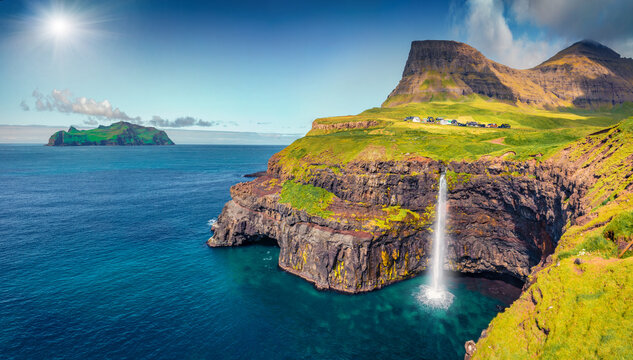 Aerial landscape photography. Sunny morning scene of Mulafossur Waterfall. Splendid summer view of Vagar island, Faroe Islands, Denmark, Europe. Beauty of nature concept background.