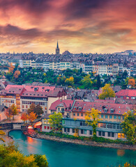 Obraz premium Wonderful evening cityscape of Bern town with Cathedral of Bern on background. Impressive autumn sunset on Switzerland, Aare River, Europe. Traveling concept background.