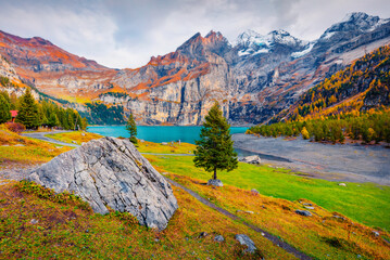 Spectacular autumn view of unique Oeschinensee Lake. Gloomy morning scene of Swiss Alps with Bluemlisalp summit on background. Beautiful autumn scenery..