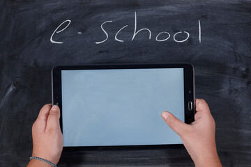 kid holding a tablet on wooden table. e-learning school. - 402801510